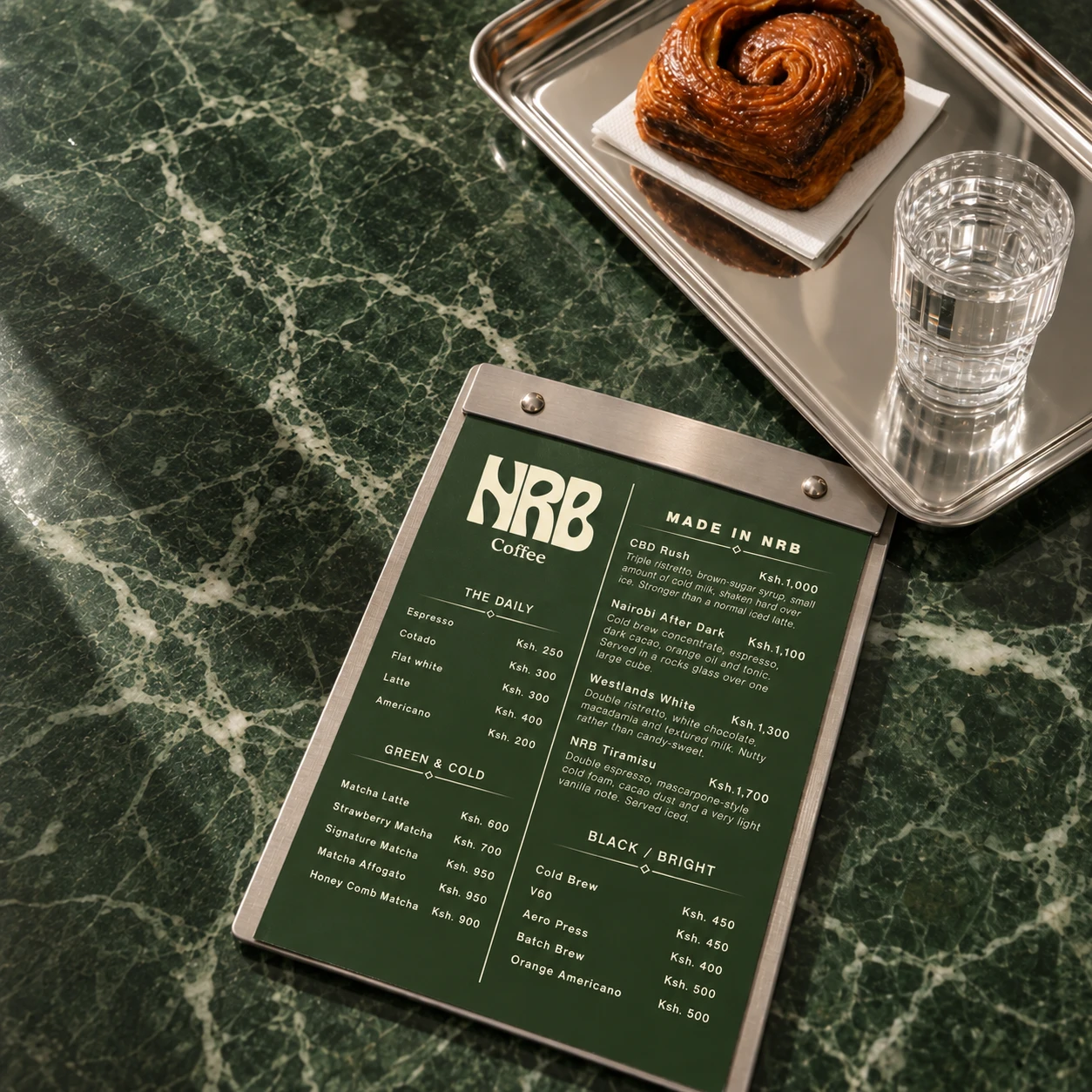 NRB concept menu on a café-style table beside a pastry and glass